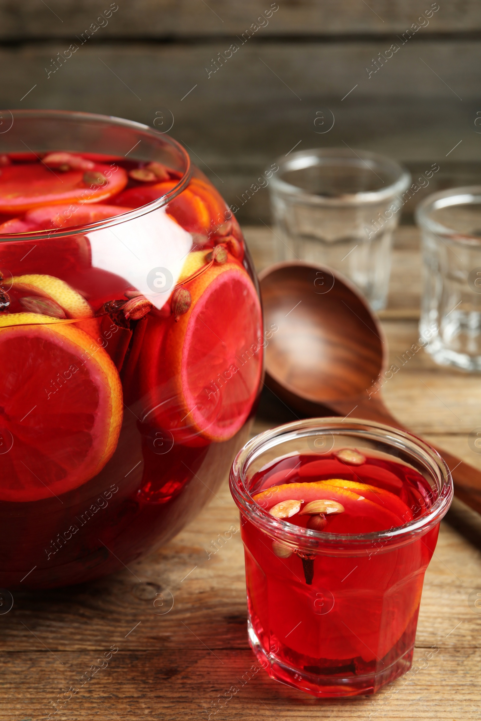 Photo of Aromatic punch drink with citrus fruits on wooden table