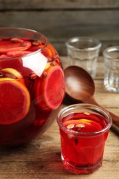 Photo of Aromatic punch drink with citrus fruits on wooden table