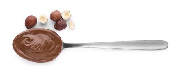 Spoon with delicious chocolate paste and hazelnuts on white background, top view