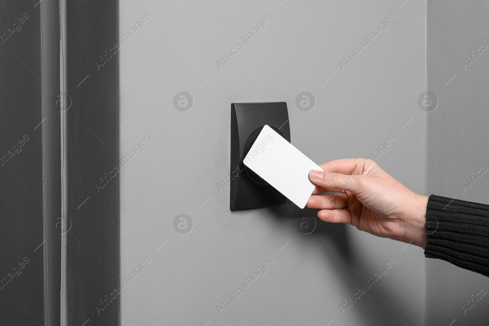 Photo of Woman opening magnetic door lock with key card, closeup. Home security