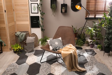 Lounge area interior with comfortable armchair and beautiful houseplants