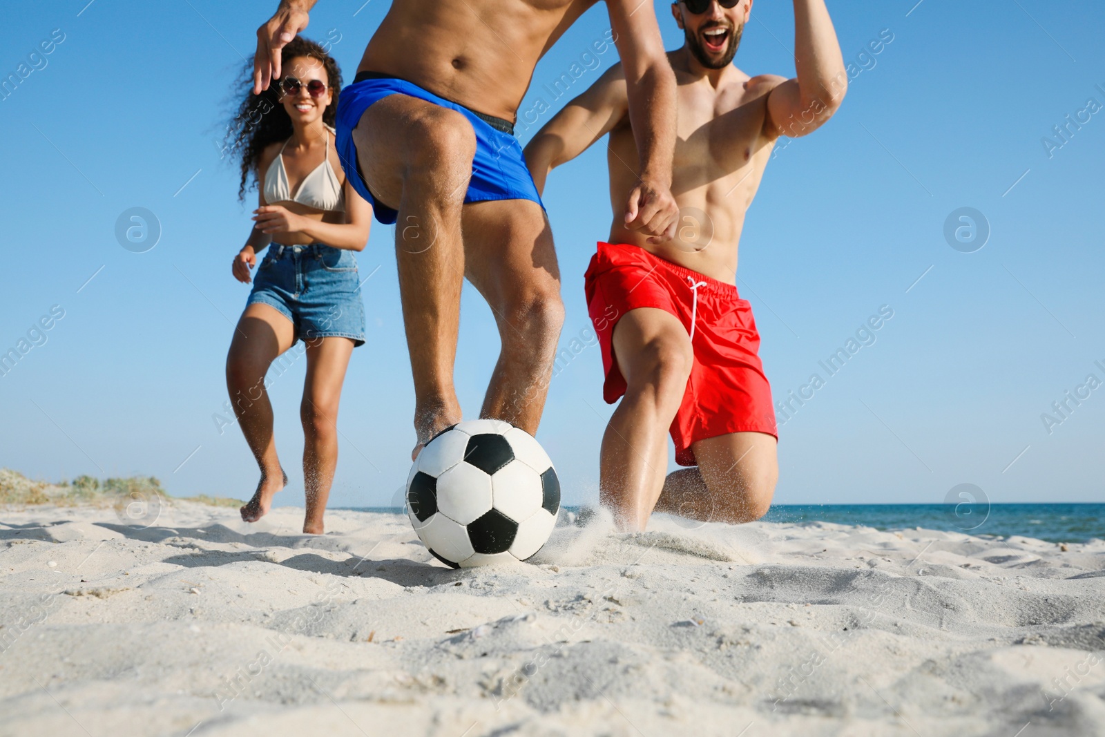 Photo of Group of friends playing football on beach