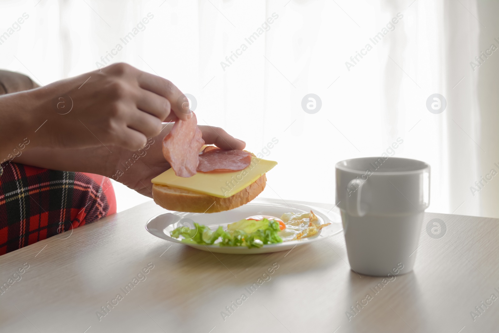 Photo of Woman preparing tasty nutritious breakfast at wooden table indoors, closeup. Good morning