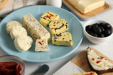 Photo of Different types of tasty butter served on white table, closeup