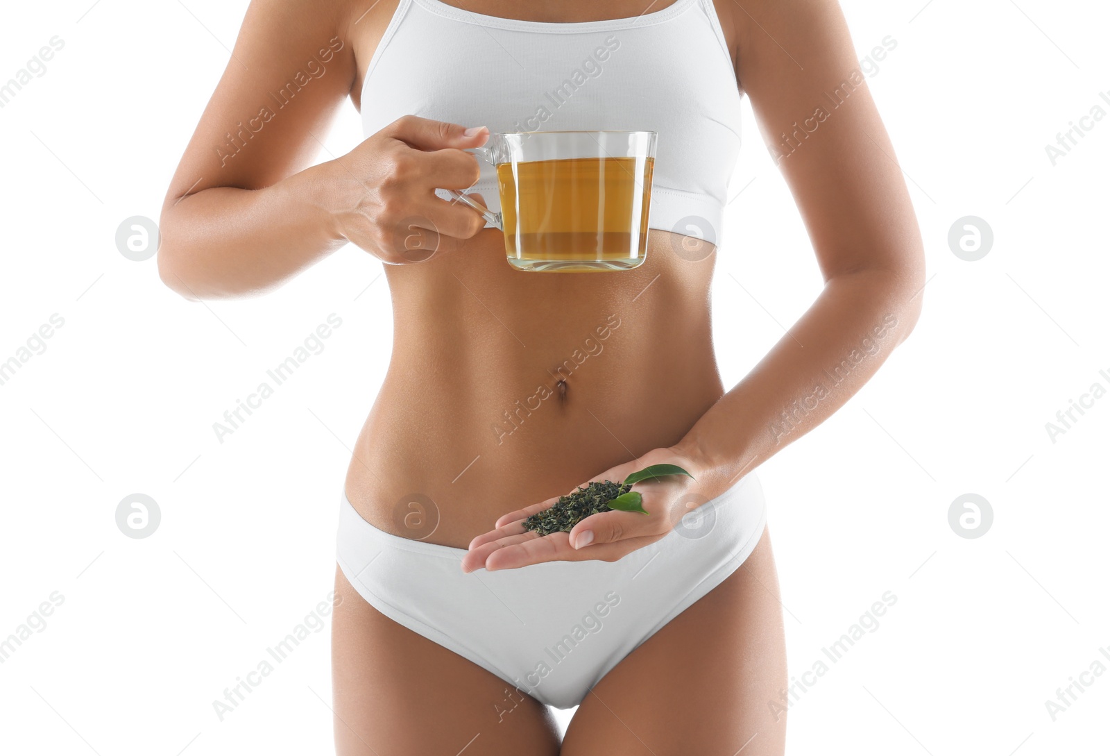 Photo of Young woman with fresh and dry leaves holding cup of diet tea on white background, closeup