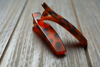 Stylish hair clips on grey wooden table