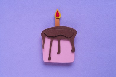 Paper birthday cake with candle on violet background, top view