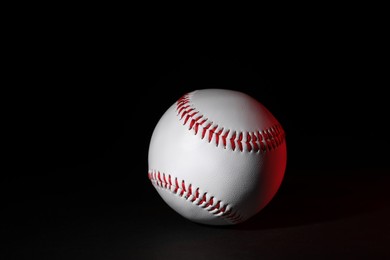 Photo of One leather baseball ball on black background