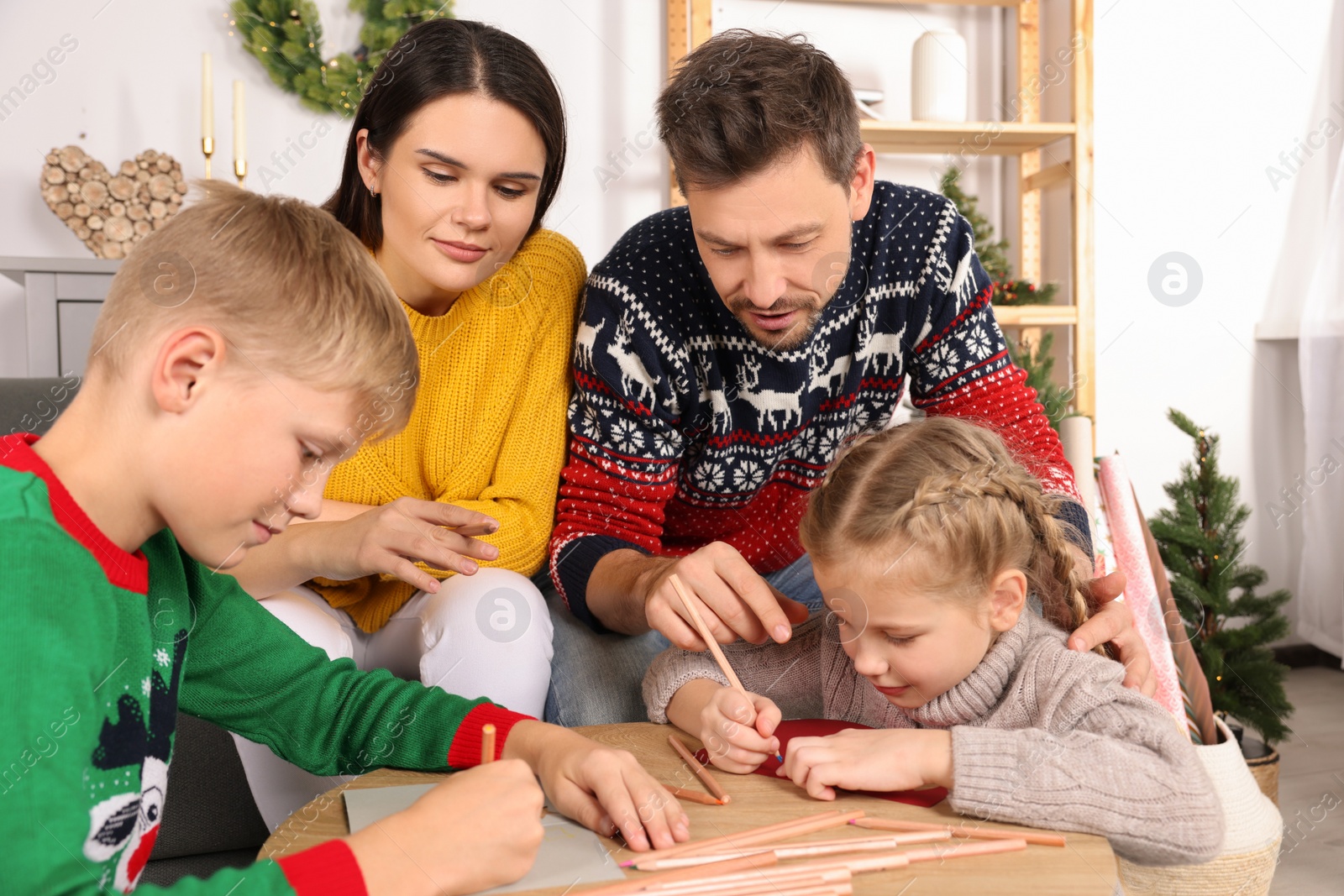 Photo of Cute children with their parents making beautiful Christmas greeting cards at home