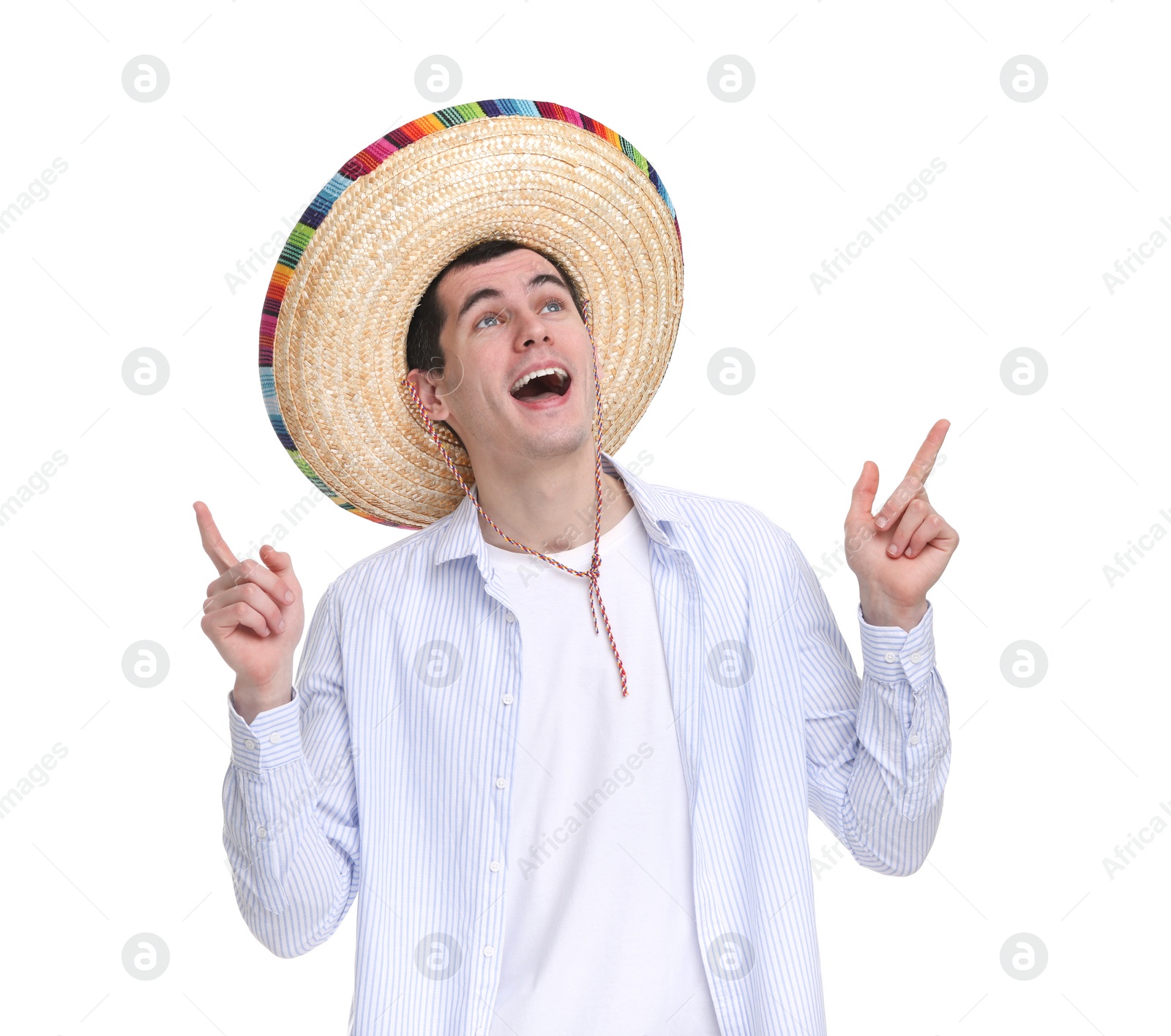 Photo of Young man in Mexican sombrero hat pointing at something on white background