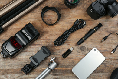 Photo of Flat lay composition with camera and video production equipment on wooden table