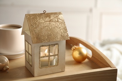 Photo of Composition with house shaped candle holder on wooden tray. Christmas decoration