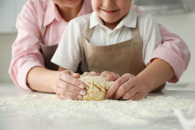 Photo of Mother and son cooking together at table, closeup