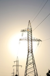 High voltage towers at sunset, low angle view