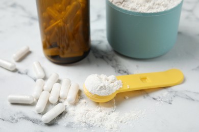 Photo of Amino acid pills and powder on white marble table