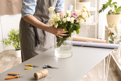 Photo of Male florist creating floral composition at workplace