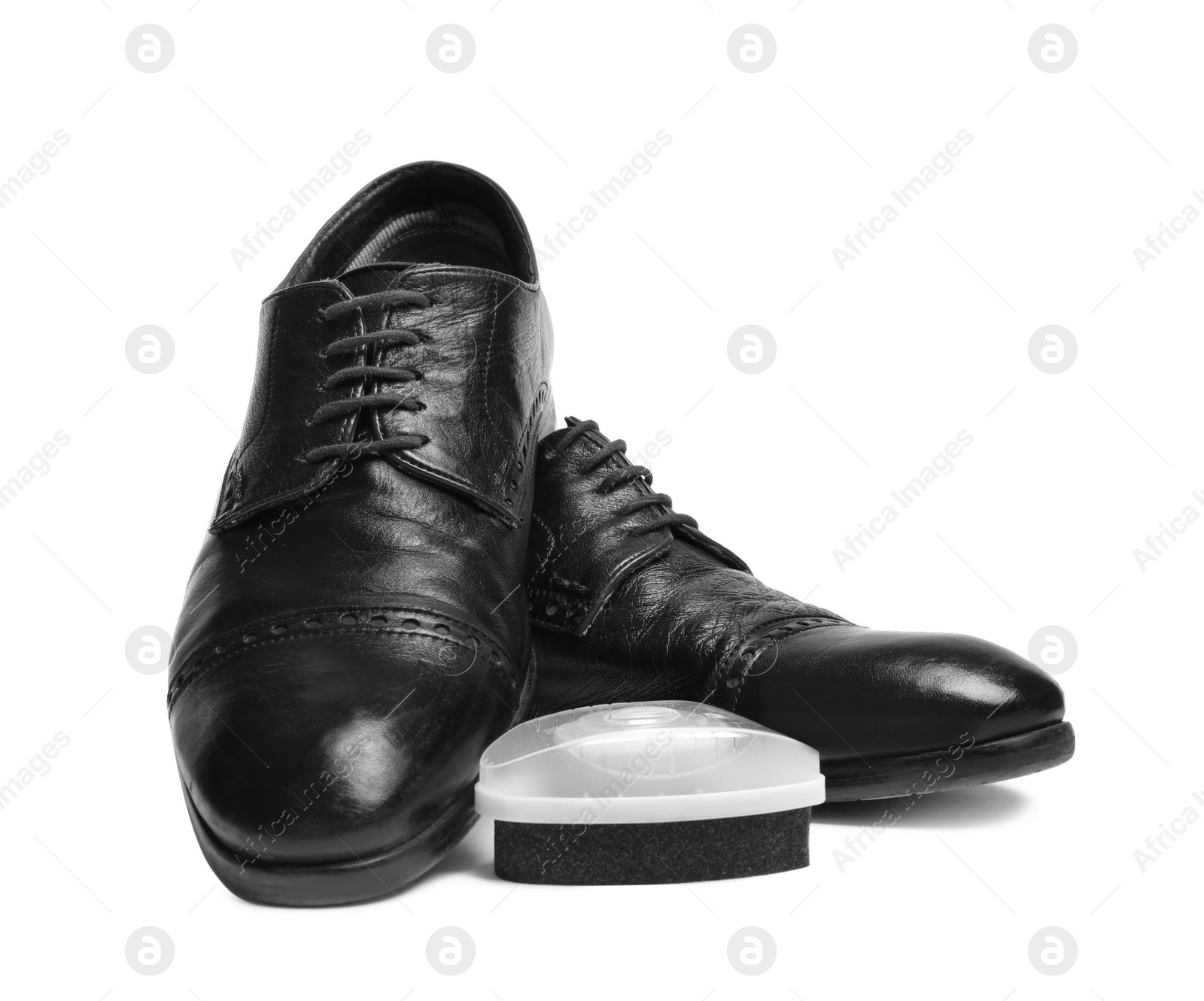Photo of Stylish men's shoes and polishing sponge on white background