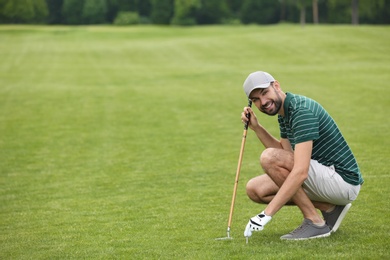 Photo of Man playing golf on green course. Space for text
