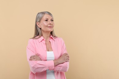 Portrait of beautiful senior woman on beige background. Space for text