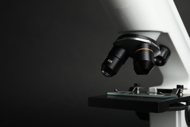 Closeup view of modern microscope on black background, space for text. Medical equipment