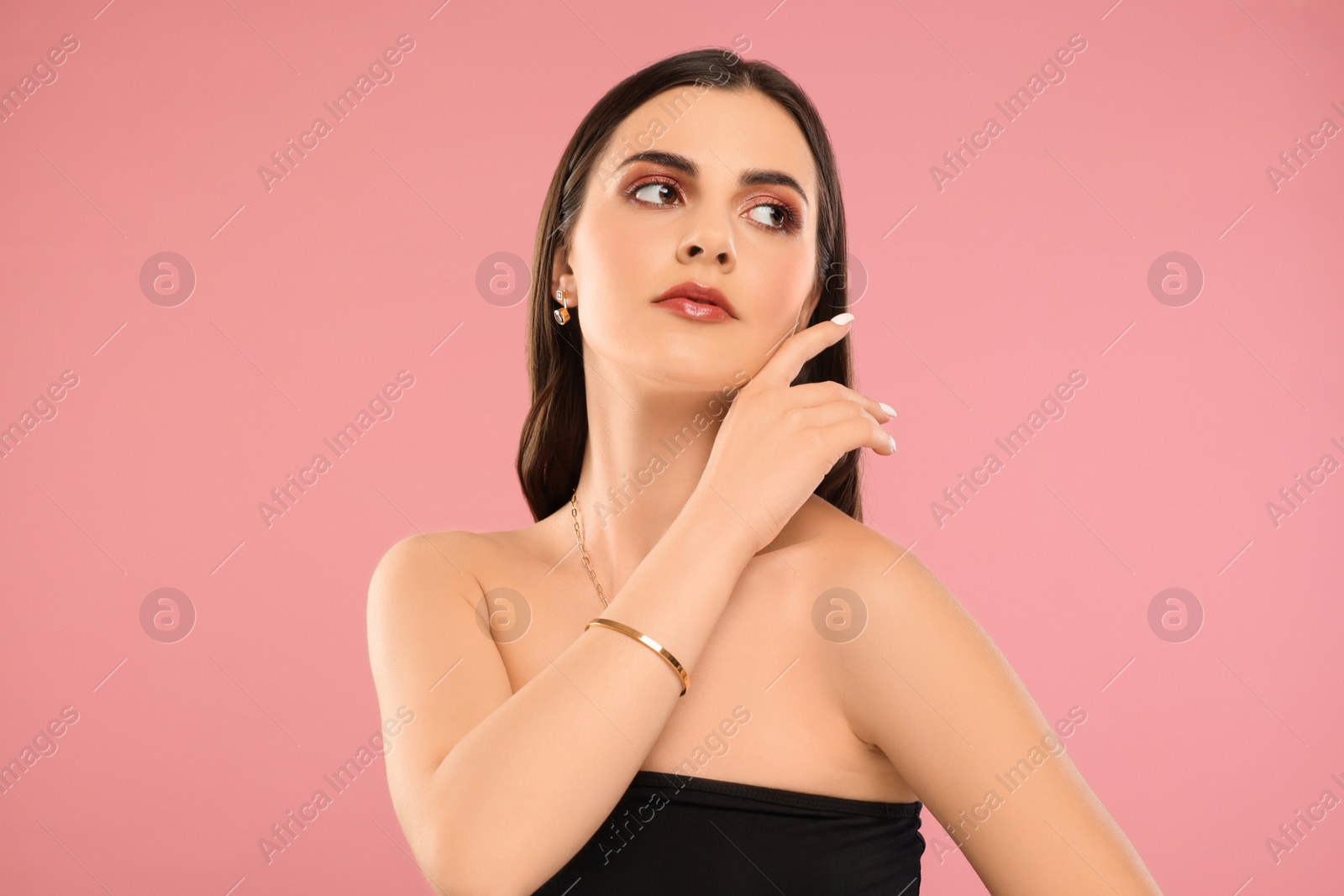 Photo of Beautiful woman with elegant jewelry on pink background