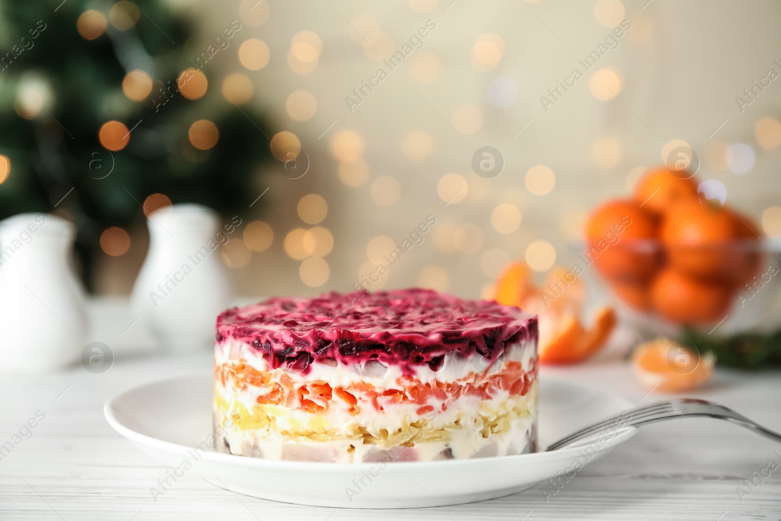 Photo of Herring under fur coat served on white wooden table, space for text. Traditional russian salad