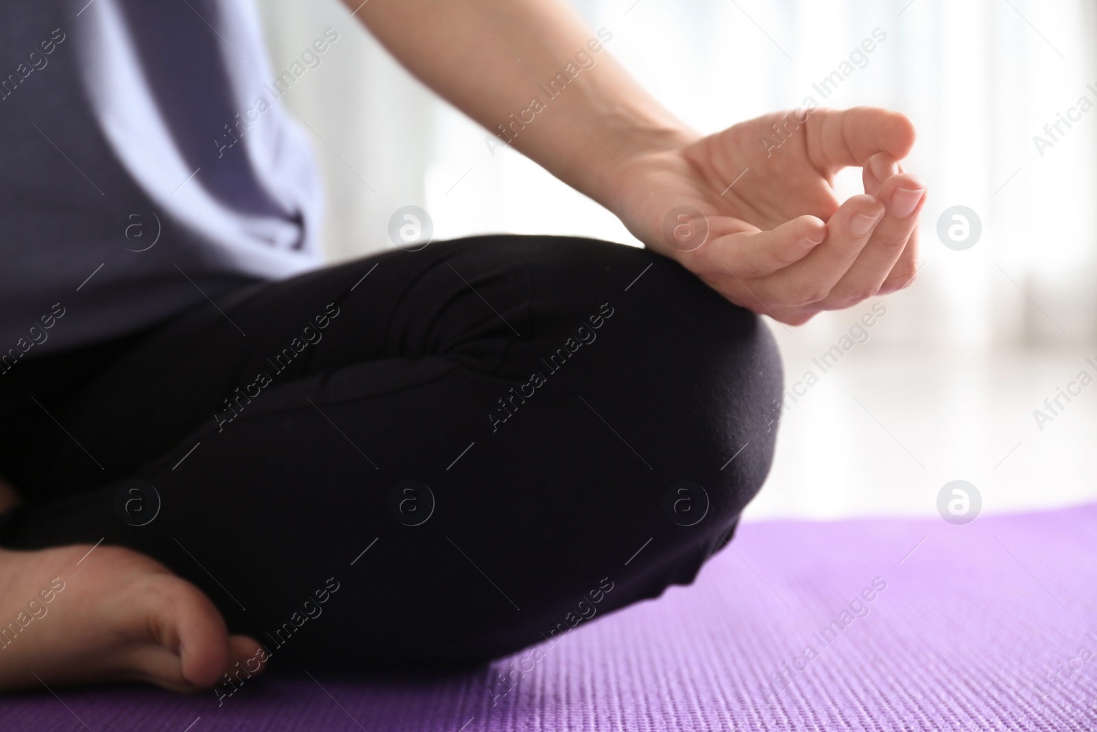 Photo of Woman practicing yoga on floor indoors, closeup