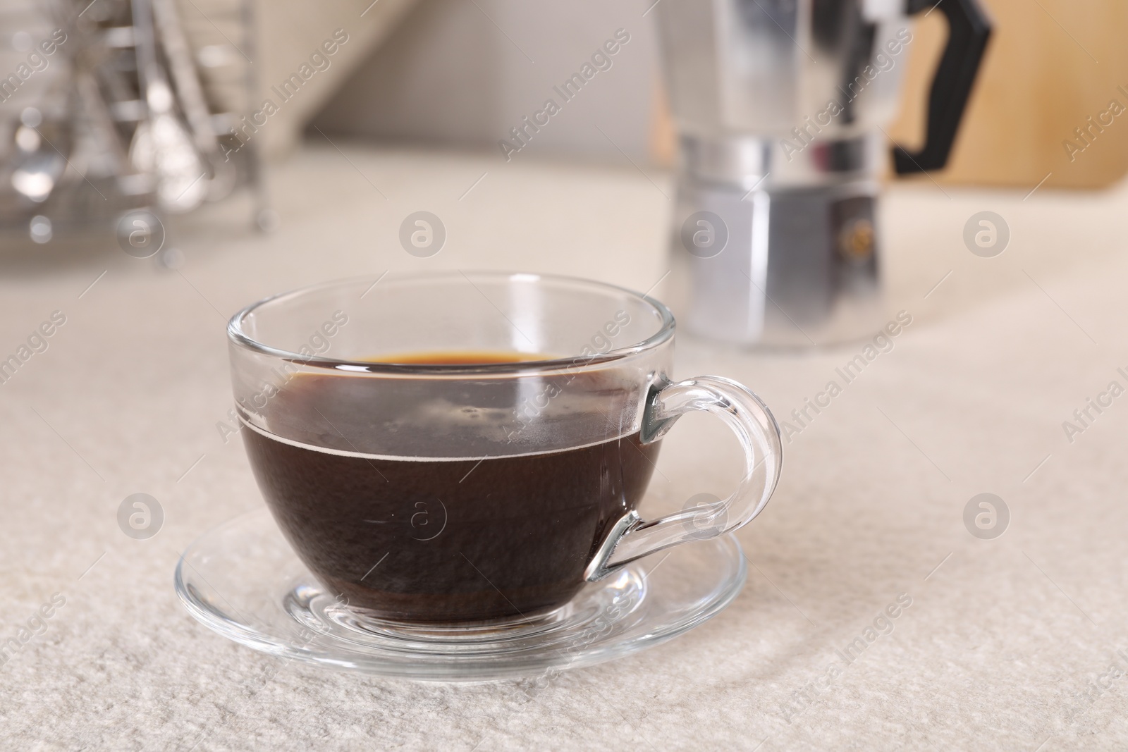 Photo of Delicious coffee in cup on light textured table, closeup