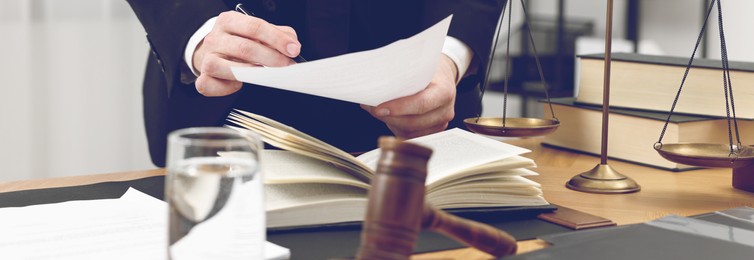 Lawyer working with document at table in office, closeup. Banner design