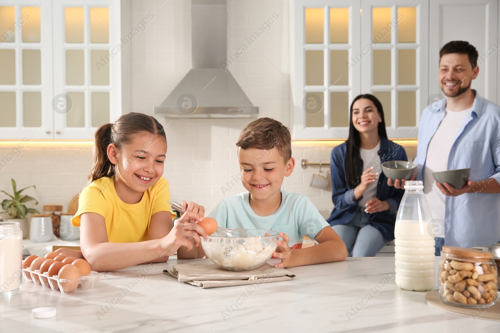 Photo of Happy family cooking together at table in kitchen. Adoption concept