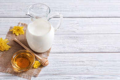 Photo of Beautiful composition with milk and honey on wooden background