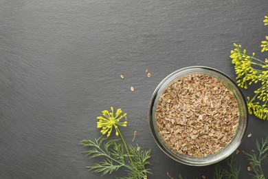 Dry seeds and fresh dill on black table, flat lay. Space for text