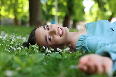 Photo of Beautiful woman lying on green grass in park. Spring sunny day