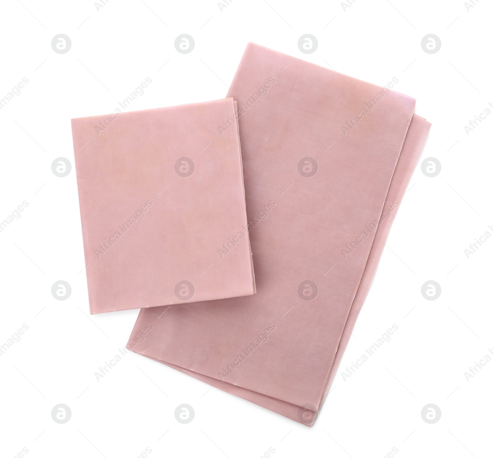 Photo of Pink reusable beeswax food wraps on white background, top view