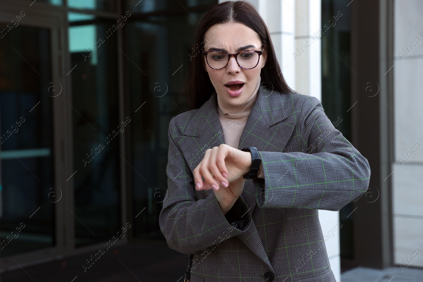 Photo of Emotional woman checking time on watch outdoors. Being late concept