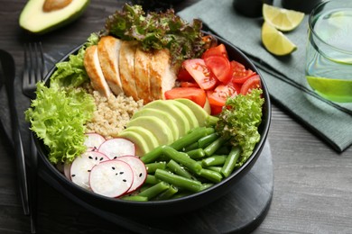 Photo of Healthy meal. Tasty products in bowl on black wooden table