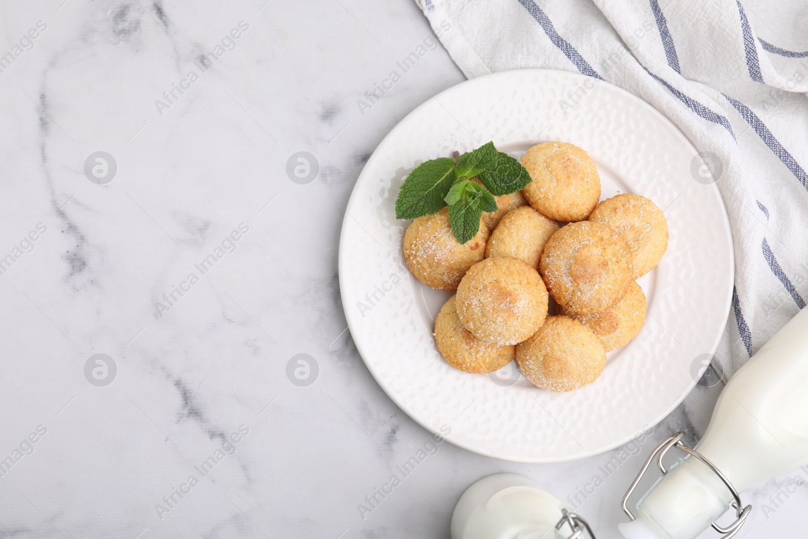 Photo of Tasty sweet sugar cookies, milk and mint on white marble table, top view. Space for text