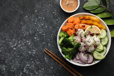 Photo of Bowl with many different vegetables and rice on grey textured table, flat lay and space for text. Vegan diet