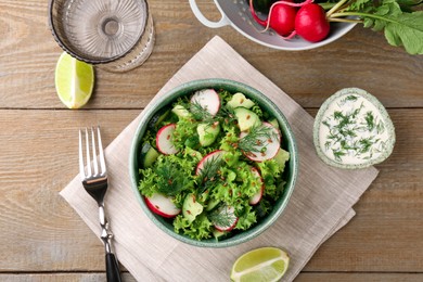 Delicious salad with radish, cucumber and lettuce served on wooden table, flat lay