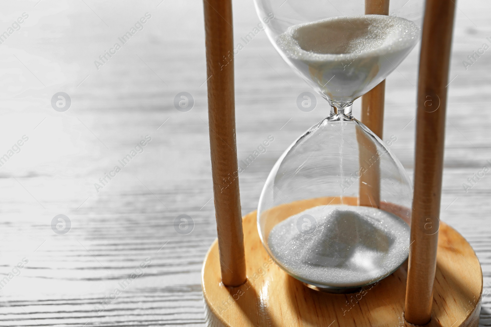 Photo of Hourglass with flowing sand on wooden background. Time management