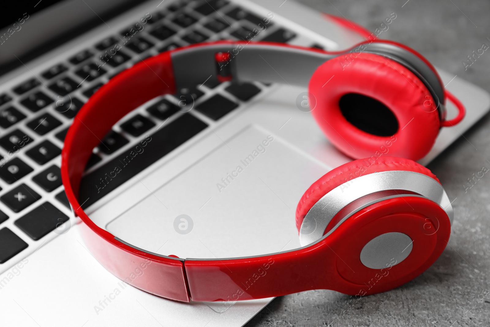 Photo of Modern headphones and laptop on table, closeup