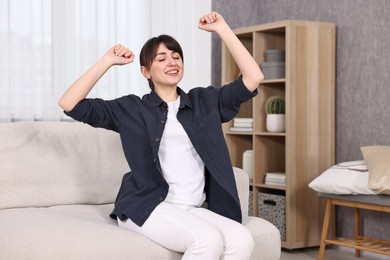 Photo of Beautiful young housewife on sofa at home