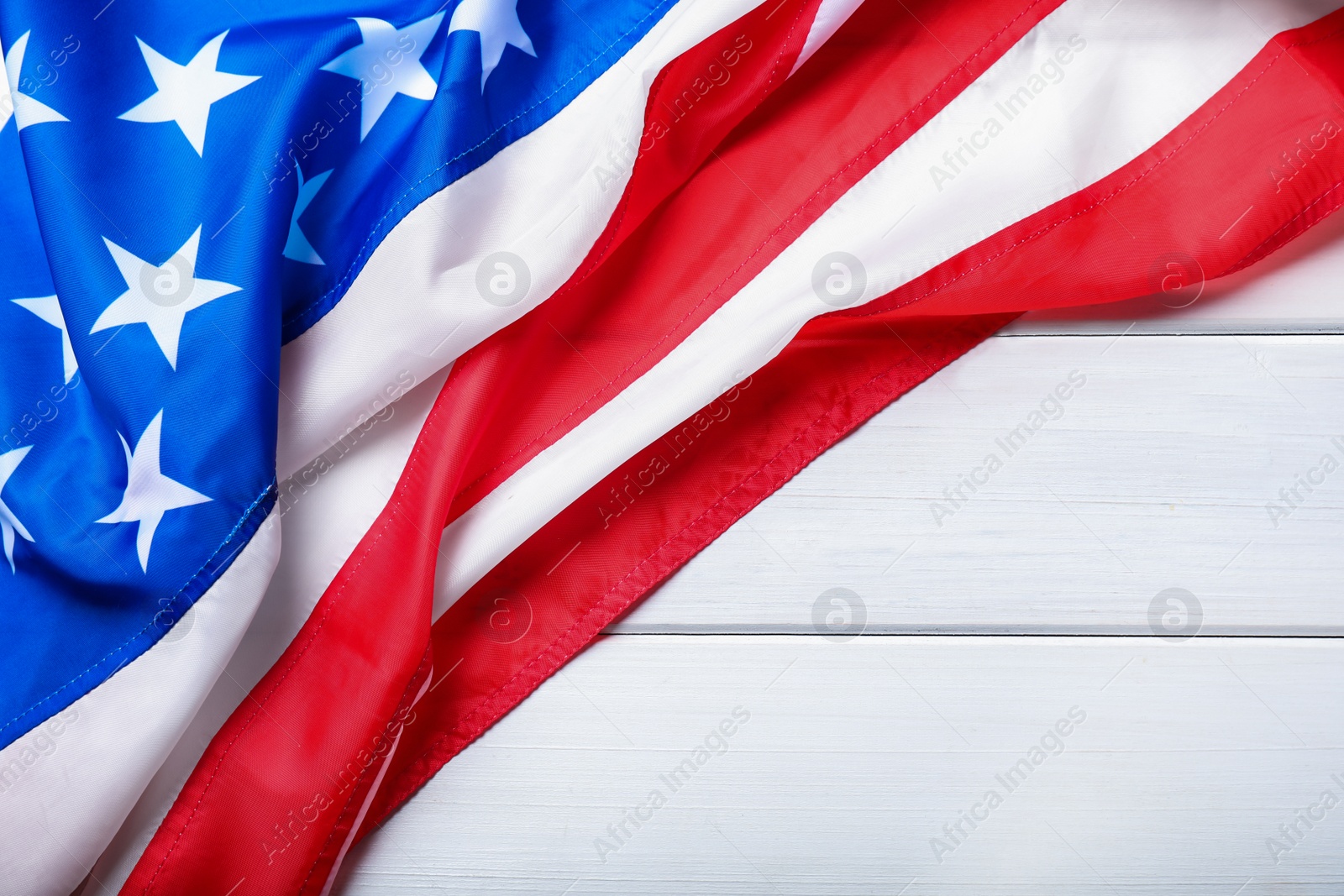 Photo of National flag of America and space for text on white wooden table, top view