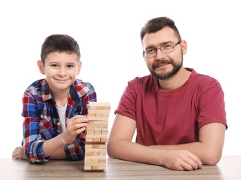 Photo of Little boy and his dad playing board game on white background