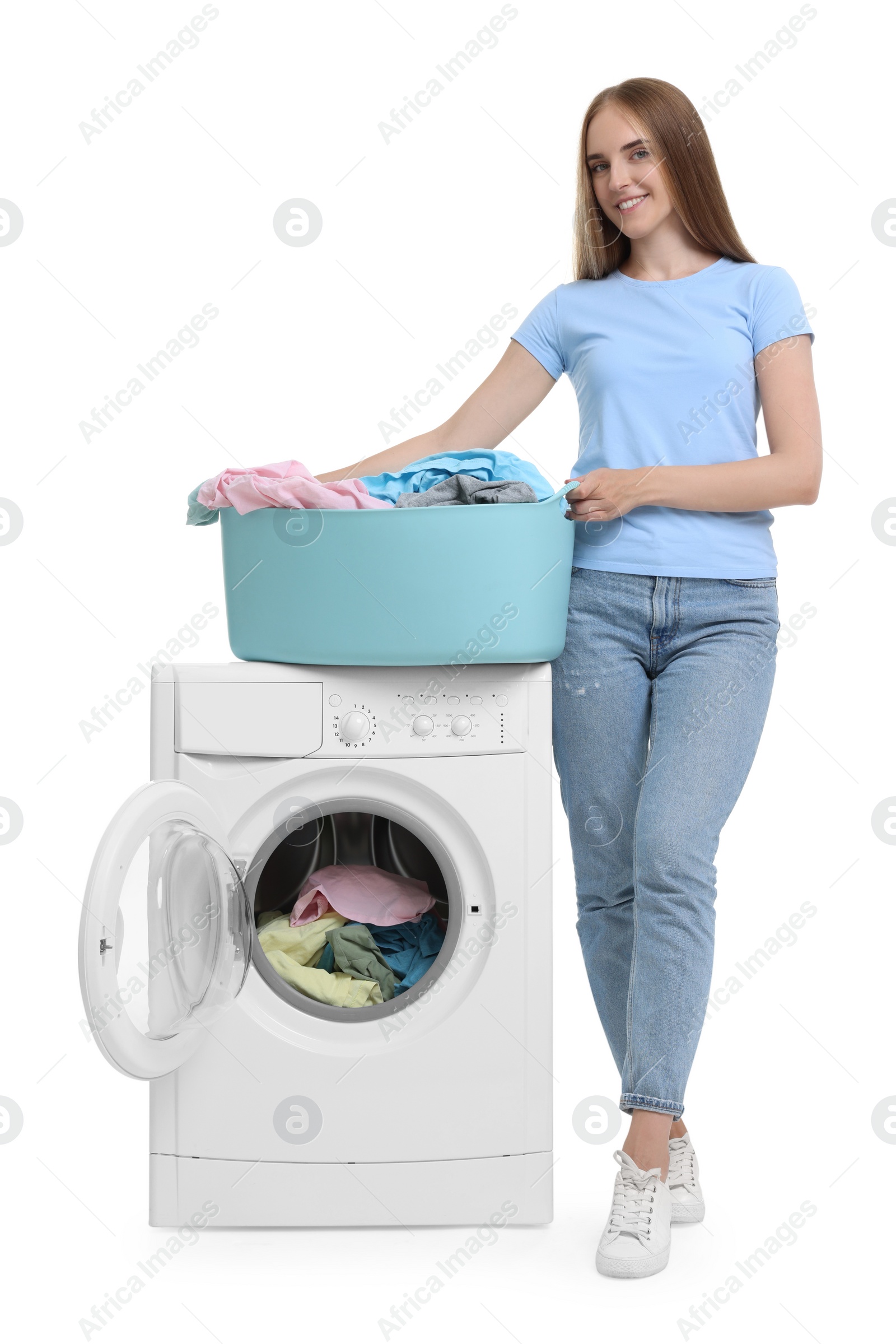 Photo of Beautiful young woman with laundry near washing machine on white background