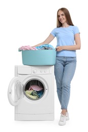 Beautiful young woman with laundry near washing machine on white background