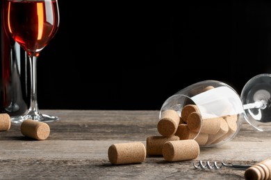 Photo of Glass of red wine, corks and corkscrew on wooden table