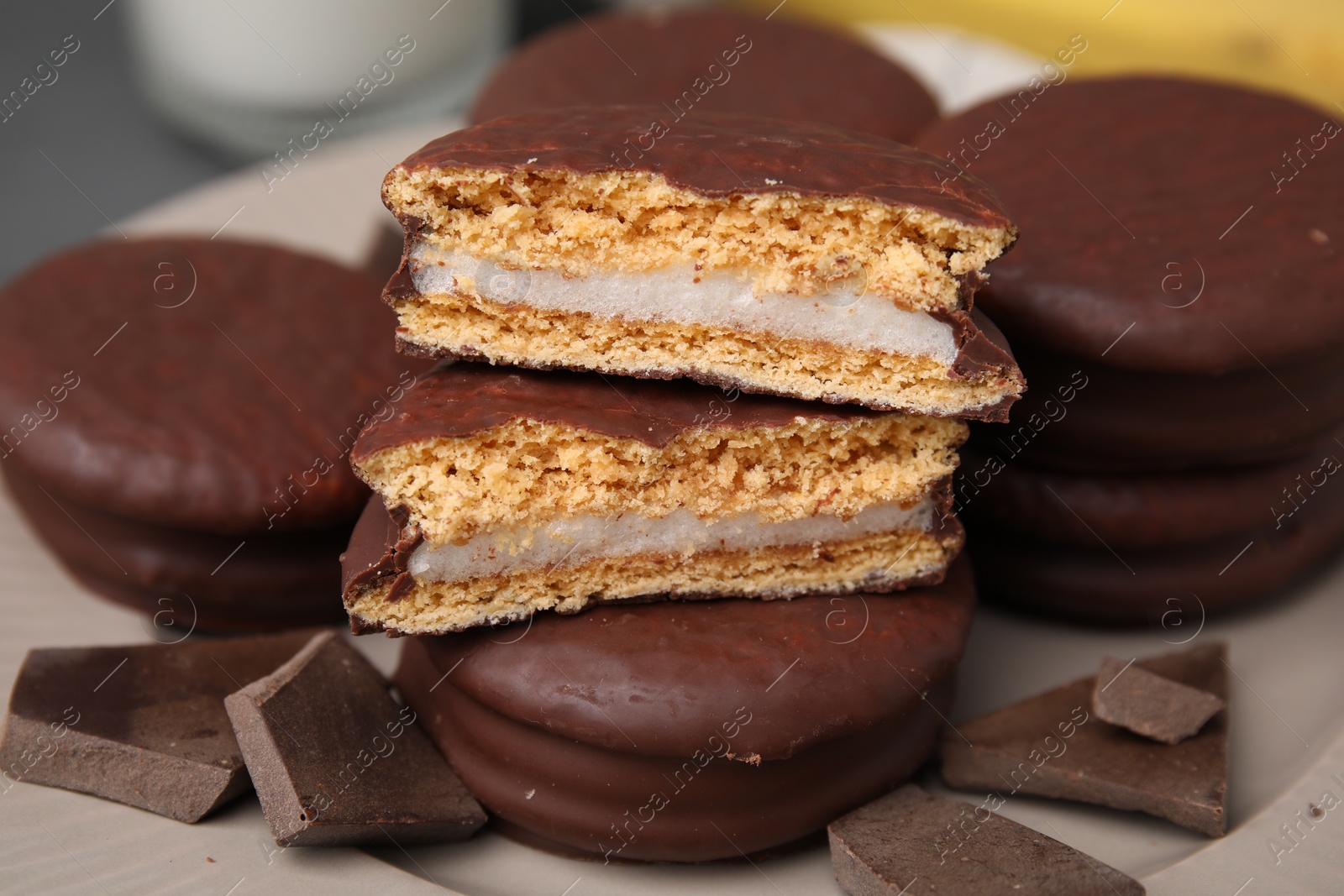 Photo of Tasty choco pies and pieces of chocolate on plate, closeup