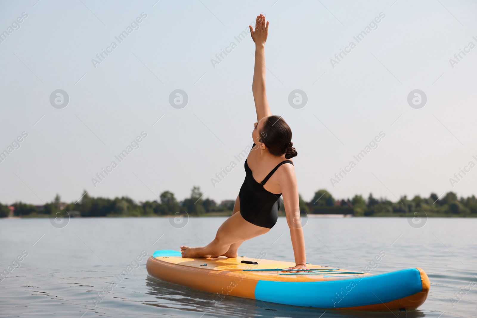 Photo of Woman practicing yoga on SUP board on river