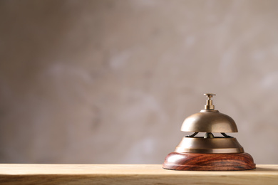 Photo of Hotel service bell on wooden table. Space for text